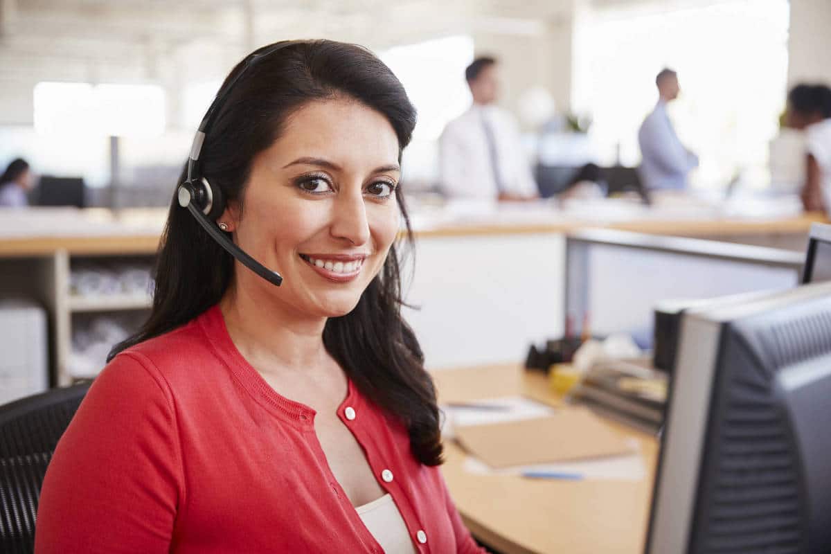 Hispanic woman working in a call centre smiling to camera