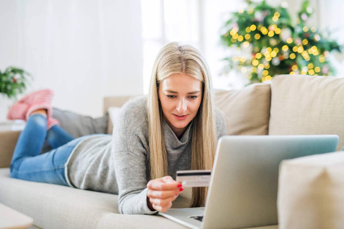 A young woman with credit card and laptop at home 