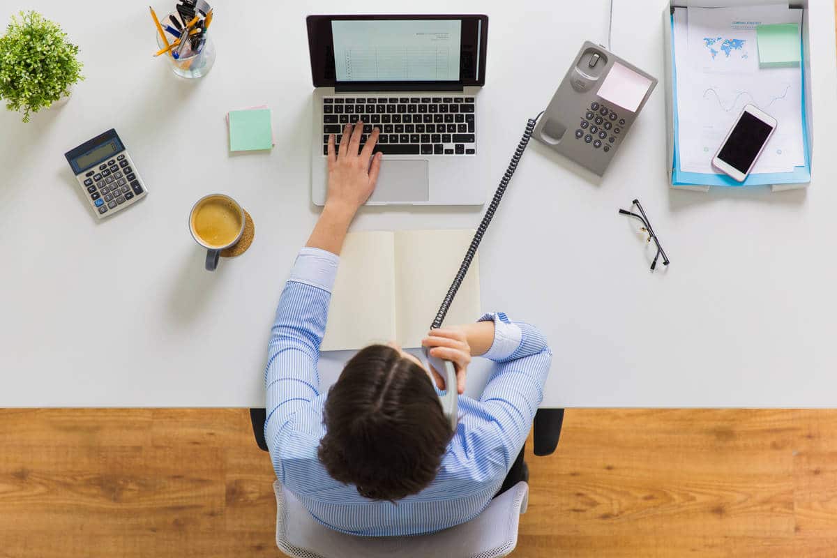 businesswoman calling on phone at office table