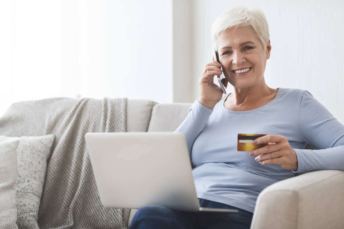 Mature lady shopping online with credit card and laptop