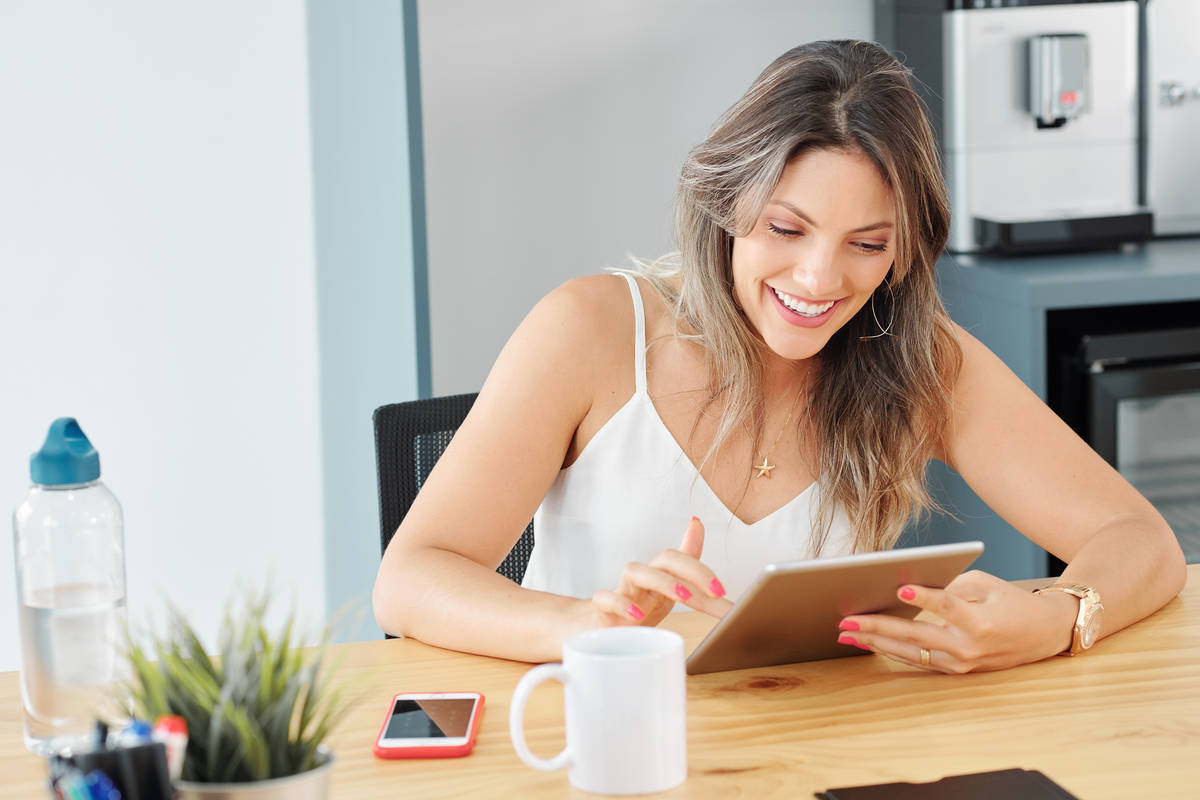 Reading emails. Женщина отвлекается на планшет.