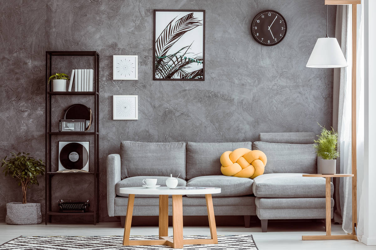 Black clock above grey settee