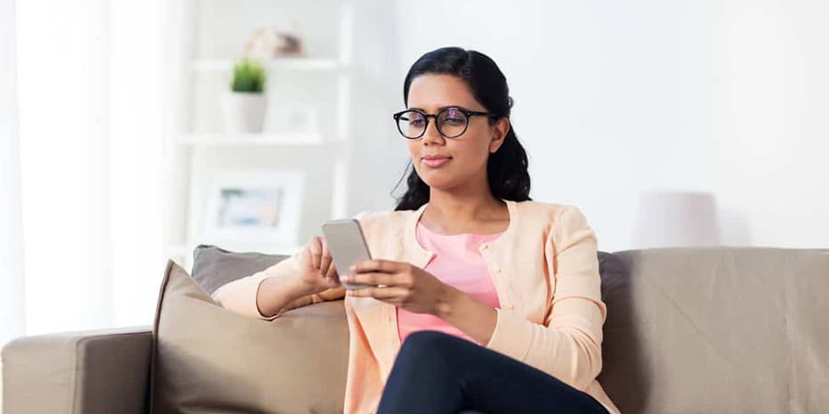 happy woman texting message on smartphone at home